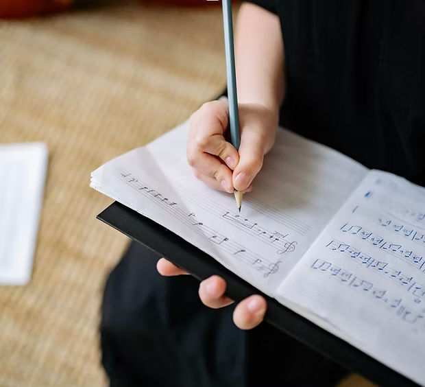 A person writing and learning staff notations