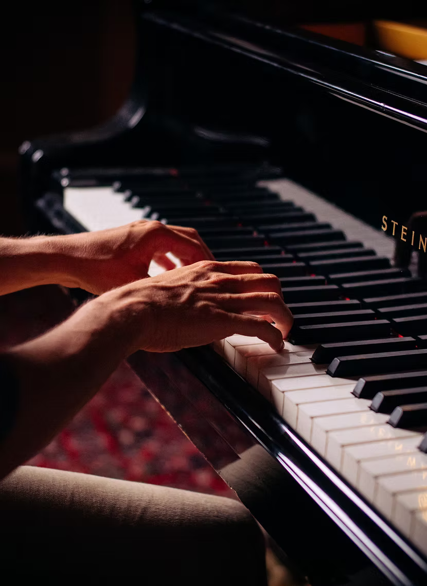 A person's hand playing the keys of a piano